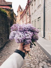 Human hand of woman holding flowers in city