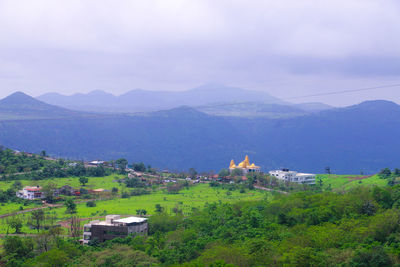Scenic view of mountains and buildings against sky