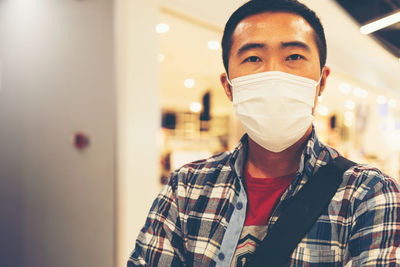 Portrait of man wearing mask standing at store