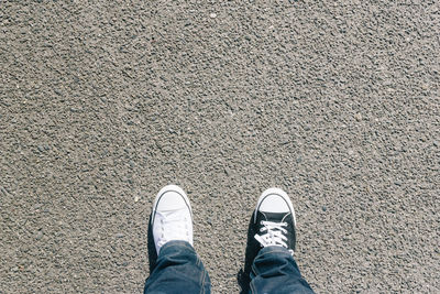 Low section of man wearing different shoes on street