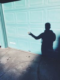 Optical illusion of shadow holding doorknob