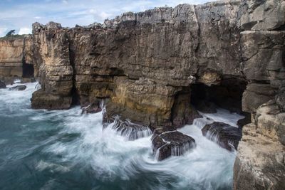 Scenic view of rocks in sea against sky