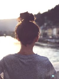 Rear view of woman against sky during sunset