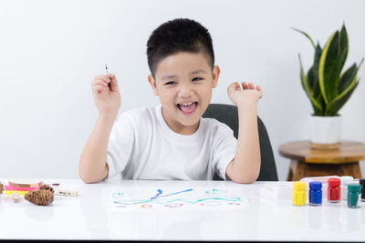 Portrait of cute boy holding table