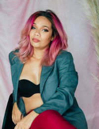 Portrait of young woman sitting on bed