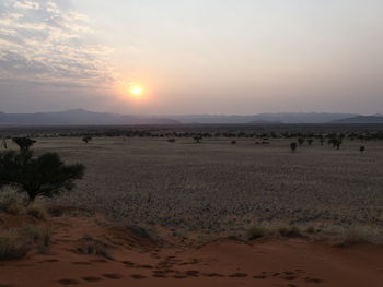 Scenic view of desert against sky during sunset