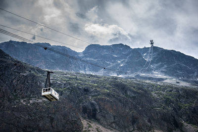 Overhead cable car over snowcapped mountains against sky