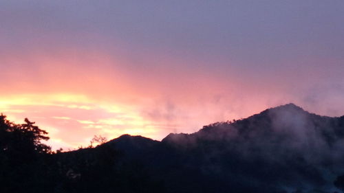 Scenic view of silhouette mountains against sky at sunset