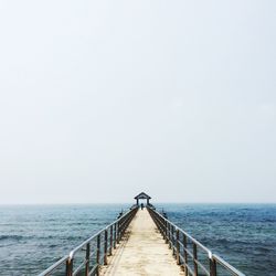 Pier against clear sky at sea