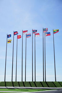 Low angle view of flags against clear sky