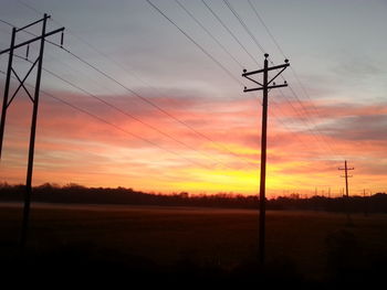 Electricity pylon against sky at sunset