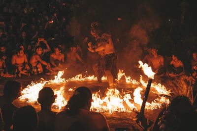 People sitting by fire at night