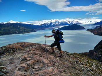 Side view of hiker hiking on mountain against sky