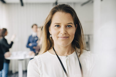 Portrait of smiling businesswoman standing in office