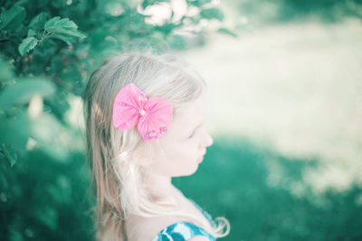 Close-up of girl with pink flower