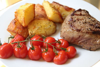 Cherry tomatoes and steak in plate