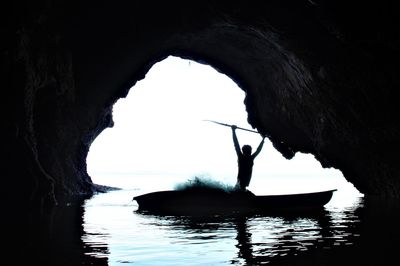 Silhouette of rock formation in sea