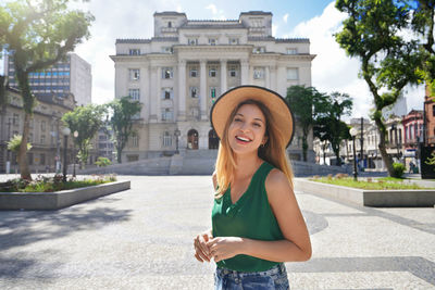 Portrait of beautiful traveler girl visiting santos historic center on sunny day, brazil