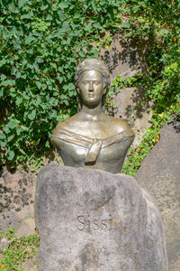 Old statue against plants