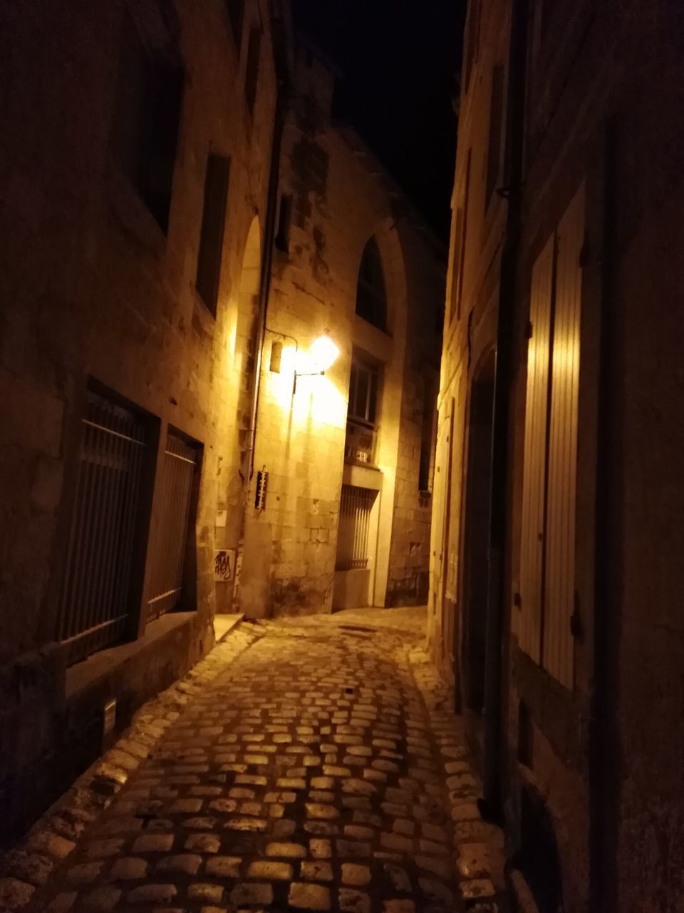 VIEW OF EMPTY ALLEY AMIDST BUILDINGS AT NIGHT
