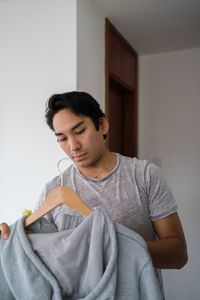 Latin man choosing clothing from his wardrobe