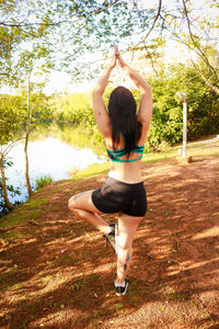 Full length of woman exercising on field