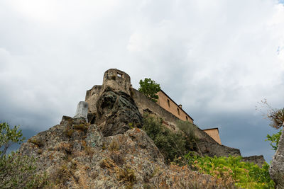 Low angle view of castle on mountain against sky