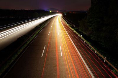 High angle view of light trail on highway against sky at night