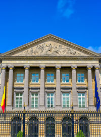 Low angle view of office building against blue sky