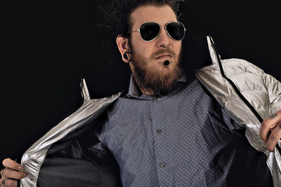 Man wearing sunglasses against black background