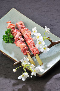 High angle view of flowers and meat in plate