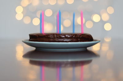 Festive birthday cake, burning candles against bright bokeh background. greeting card. party