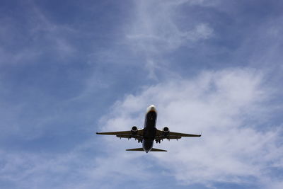 Low angle view of airplane flying against sky