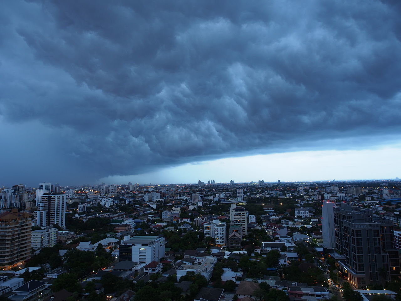 HIGH ANGLE VIEW OF CITY BUILDINGS AGAINST CLOUDY SKY