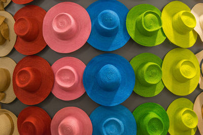 Full frame shot of multi colored hats hanging on wall for sale