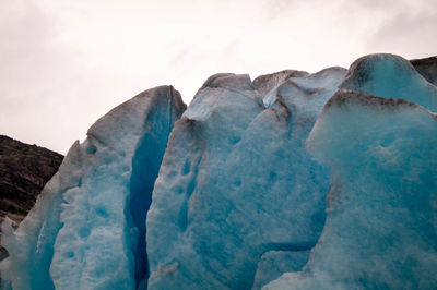 Low angle view of icicles on landscape against sky