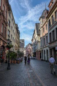 People walking on street amidst buildings in city