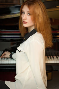 Portrait of beautiful young woman playing piano