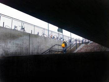 People on bridge against wall
