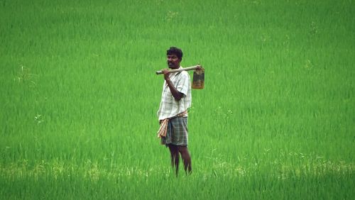 Portrait of farmer with shovel standing on rice farm