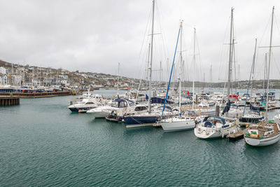 Sailboats moored in harbor