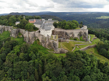 High angle view of castle on mountain against cloudy sky