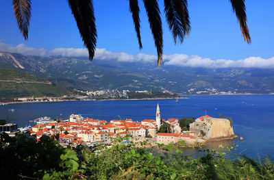 High angle view of town by sea against sky