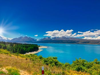 Scenic view of lake and mountains against blue sky