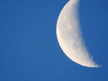 Low angle view of moon against clear blue sky