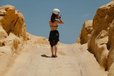 Full length of woman standing on rock