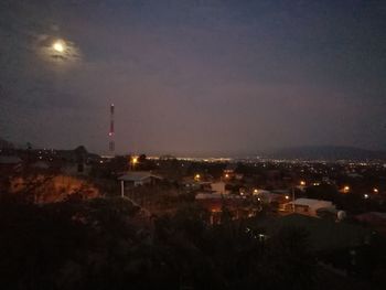 Illuminated cityscape against sky at night