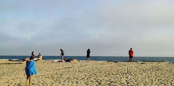 People on beach against sky