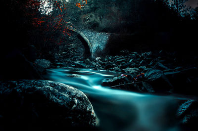 Close-up of waterfall in forest at night