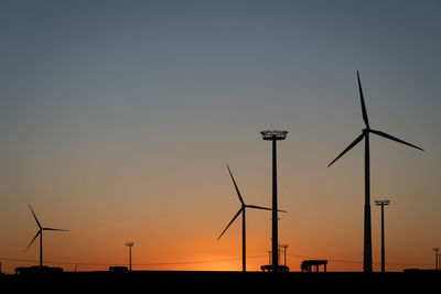 Silhouette of wind turbine against sky during sunset